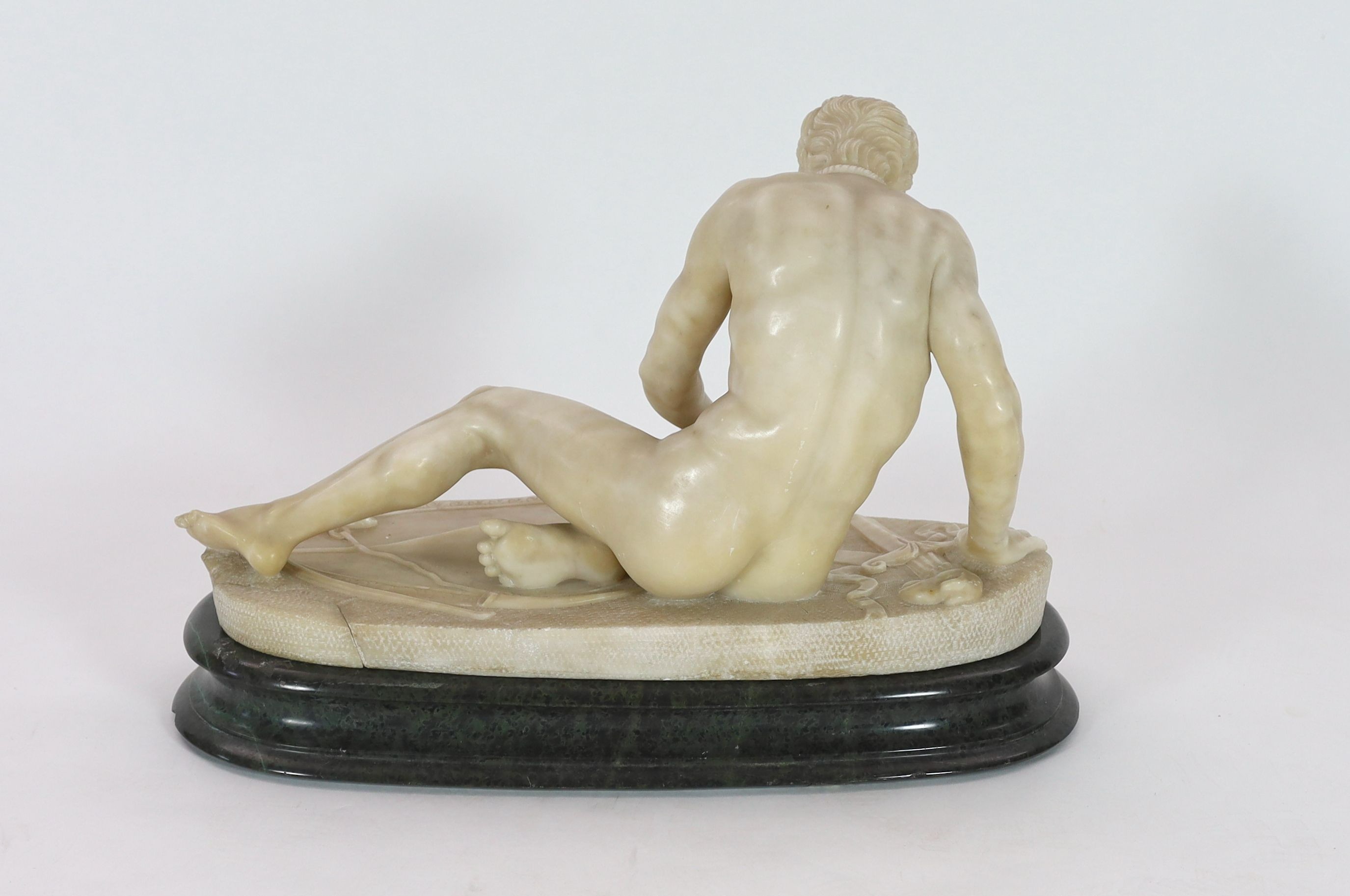 A late 19th century carved alabaster model of The Dying Gaul, width 65cm, height 43cm